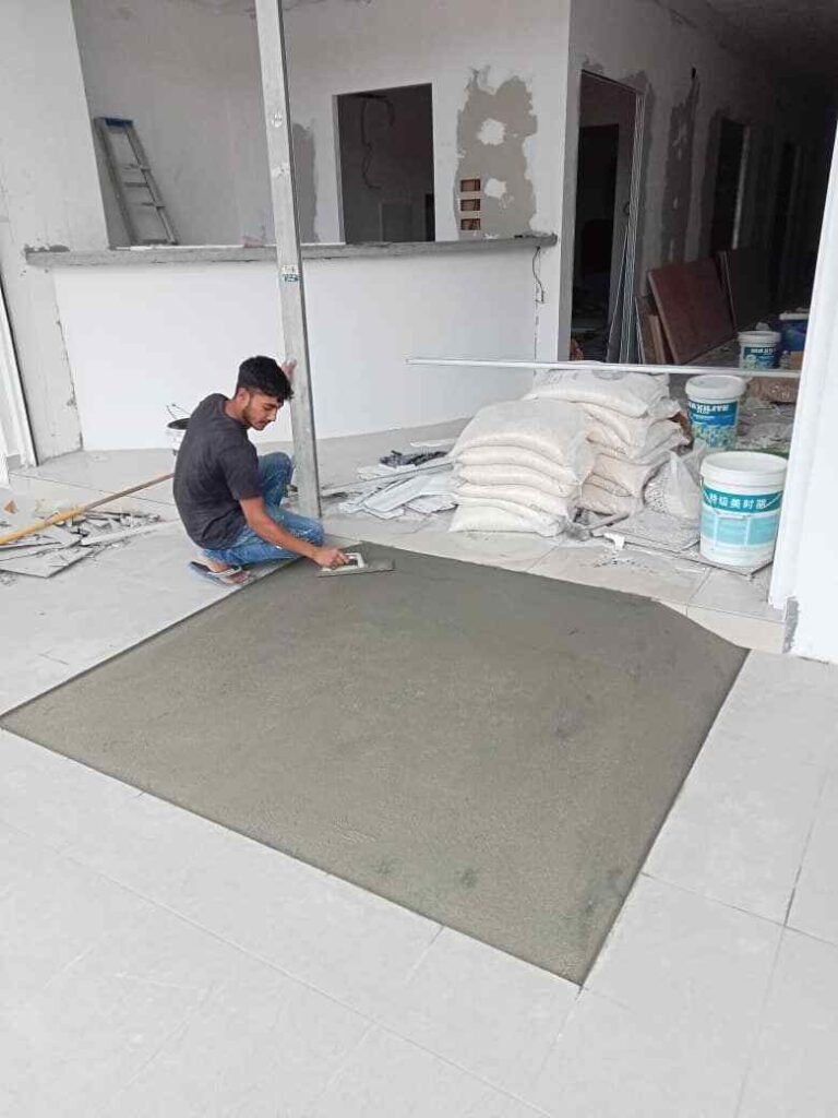 Construction worker installing tiles on a floor, ensuring precise alignment and durability.