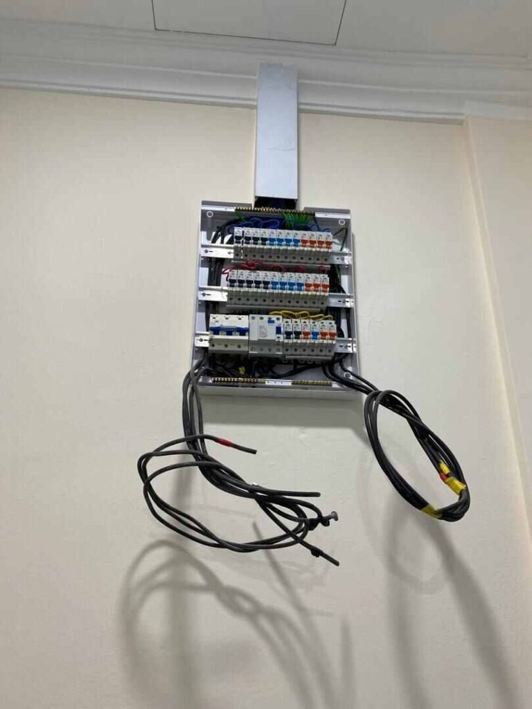 Electrical panel installation with labeled circuit breakers and conduits in a Malaysian renovation project.