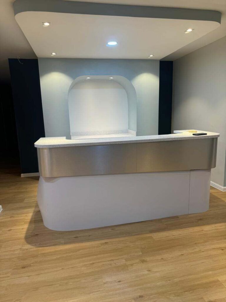 Modern reception desk with quartz countertop and recessed lighting in Malaysia.